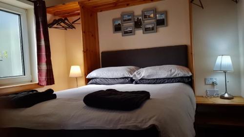 a bedroom with a large bed with two pillows on it at Tanera in Inverness
