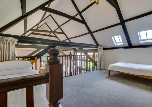 a bedroom with a bed and a balcony at Lays Barn in Rockland Saint Peter