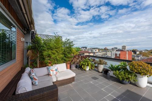a patio with a couch on a balcony with plants at Beautiful 1-Bed in St Kilda w Parking & Terrace in Melbourne