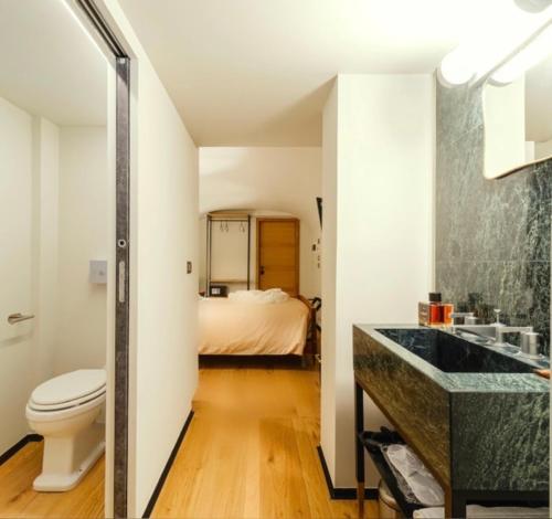 1 cama y baño con lavabo y aseo. en Club64 en Andria