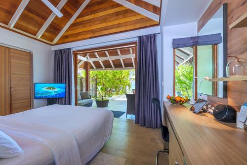 um quarto com uma cama e uma televisão num quarto em Kandolhu Maldives em Himandhoo 