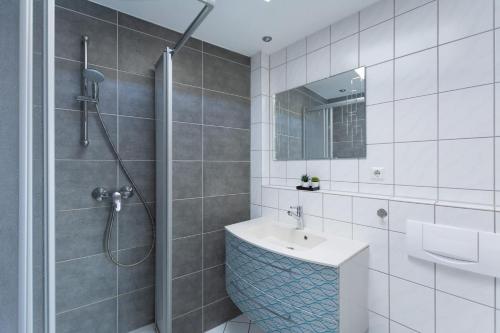 y baño blanco con lavabo y ducha. en T&K Apartments - 1-3 Zimmer Apartments - Essen, en Essen