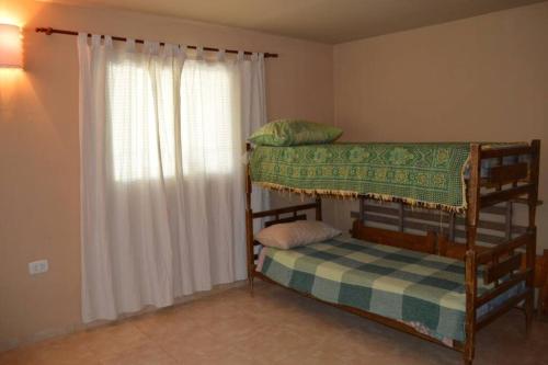 2 stapelbedden in een kamer met een raam bij Casa con pileta in Santiago del Estero