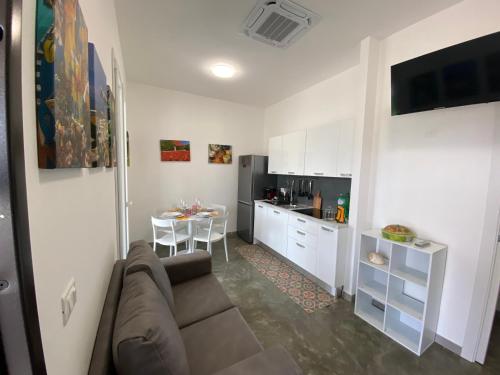 a living room with a couch and a kitchen at Verde Oliva Residence in Ispica