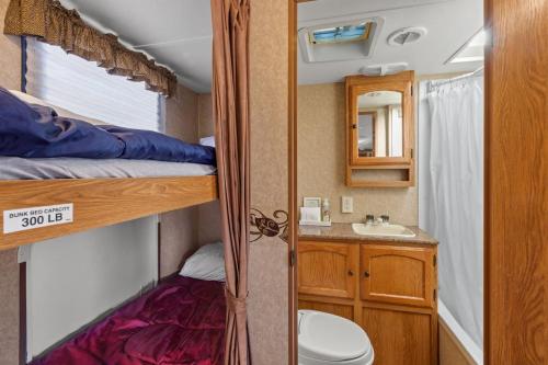 a small bathroom with a bunk bed and a sink at JT Village Campground - Bunkhouse in Joshua Tree