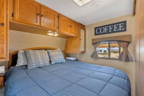 a bedroom with a blue bed in a caravan at JT Village Campground - Bunkhouse in Joshua Tree