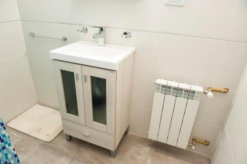 een witte badkamer met een wastafel en een handdoek bij Gente del Sur - 25 de mayo in Ushuaia