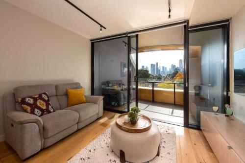 ein Wohnzimmer mit einem Sofa und einem großen Fenster in der Unterkunft 2-Bed in South Melbourne w Beautiful City Views in Melbourne