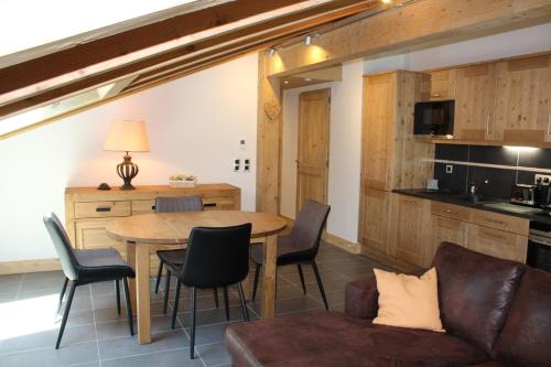 une cuisine et une salle à manger avec une table et des chaises dans l'établissement RESIDENCE SASKYA, à Samoëns
