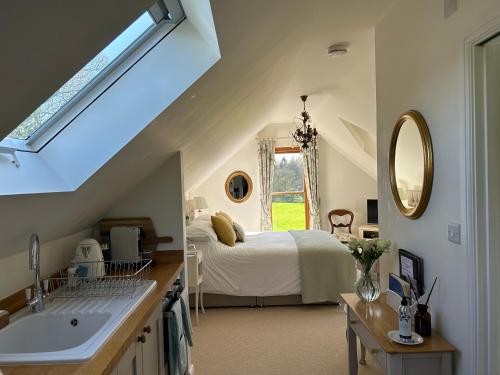 Schlafzimmer mit einem Bett, einem Waschbecken und einem Spiegel in der Unterkunft The Old Doctors Retreat- Near Soho Farmhouse in Sandford Saint Martin