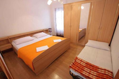 a bedroom with a large bed and a mirror at One-Bedroom Apartment Crikvenica 14 in Dramalj