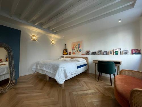 une chambre avec un lit, une table et un bureau dans l'établissement CozyStudioParis-Montmartre-Opera, à Paris