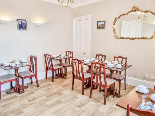 a dining room with tables and chairs and a mirror at Tanera in Inverness