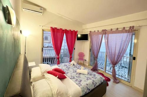 a bedroom with a bed with red curtains and a window at Apartment TAORMINA center with TERRACE, via Celestino Penna 6 in Taormina