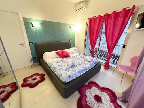 a bedroom with a bed with red curtains and red rugs at Apartment TAORMINA center with TERRACE, via Celestino Penna 6 in Taormina