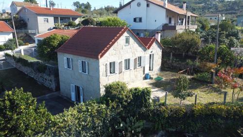 a small stone house with a red roof at Casa do Viso in Oliveira do Hospital