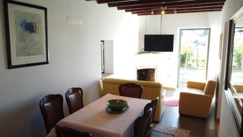 a dining room with a table and a living room at Casa do Viso in Oliveira do Hospital