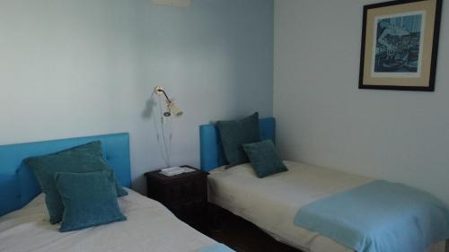 Habitación con 2 camas y lámpara. en Casa do Viso, en Oliveira do Hospital