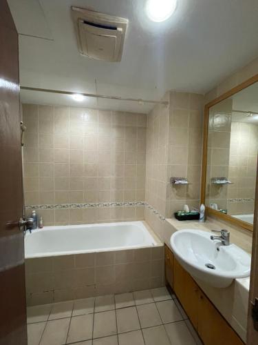 a bathroom with a bath tub and a sink at 38 Bidara service suites in Kuala Lumpur