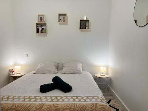 un lit avec une croix noire posée dessus dans l'établissement Appartement cosy à Toulouse, à Toulouse