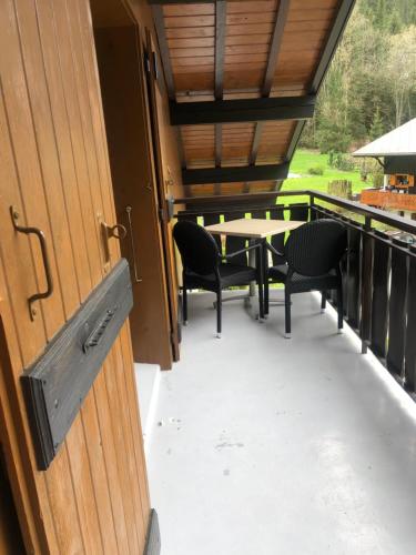 a porch with a table and chairs on a balcony at Hôtel la Kinkerne in Morzine