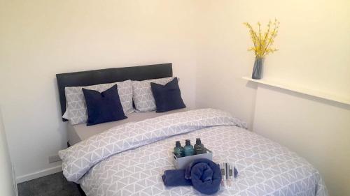 a bedroom with a white bed with blue pillows at Move inn Estates - Multiple Rooms in London
