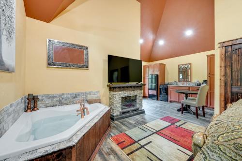 a bathroom with a tub and a television and a bed at Blissful Broken Bow Vacation Rental with Fire Pit! in Broken Bow