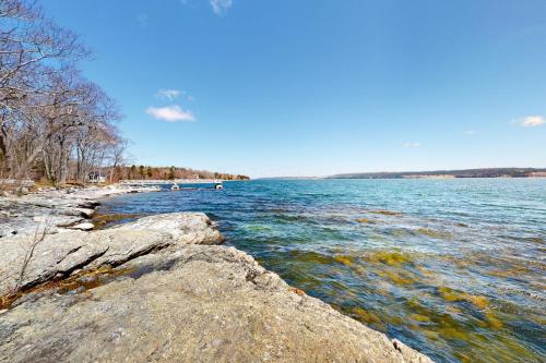 a body of water with rocks on the shore at Birds Nest in Blue Hill