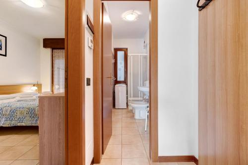 a bedroom with a bed and a bathroom with a toilet at Appartamento Assenza 9 in Brenzone sul Garda