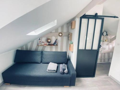 a blue couch in a room with a staircase at Le studio L'anodin - centre rive droite - 227 in Rouen