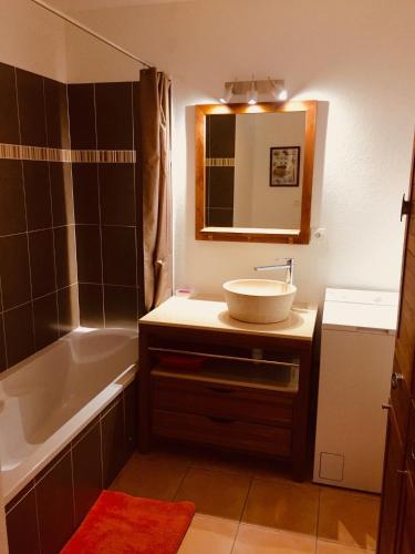 une salle de bain avec un lavabo, une baignoire et un miroir dans l'établissement Joli appartement tout confort, à Hyères