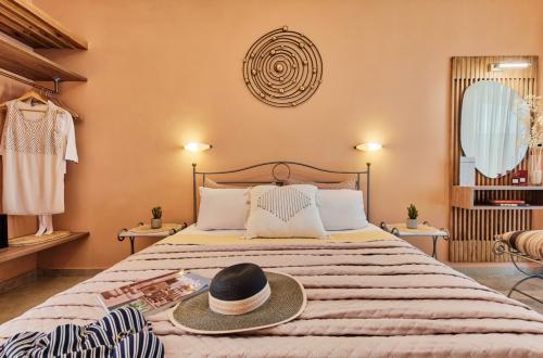 una camera da letto con un letto con un cappello sopra di Porto Roma Seaside Studios a Vasilikós