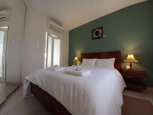 sypialnia z dużym białym łóżkiem z 2 ręcznikami w obiekcie Ayla Studio House w mieście Birżebbuġa