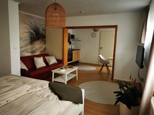 a bedroom with a bed and a living room with a couch at Ferienwohnung Landblick 