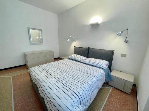 - une chambre dotée d'un lit avec des draps bleus et blancs dans l'établissement Casa Tulipano, à Levanto