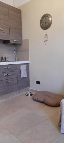 a kitchen with a dog bed and a clock on the wall at Bellaveduta Holidays Home in Baldissero Torinese