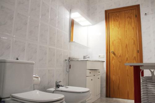 biała łazienka z toaletą i umywalką w obiekcie Vacaciones en maresme casa para 7 personas w Barcelonie