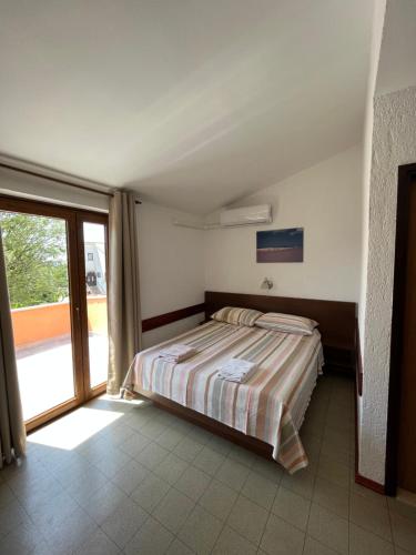 a bedroom with a bed and a large window at Rooms Danica in Poreč