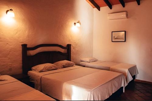 A bed or beds in a room at KAROBÉ Posada Boutique