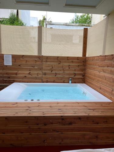 a jacuzzi tub in a room with wooden walls at Jacuzzi studio close to athens airport!! in Pallíni