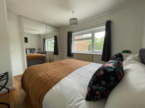 a bedroom with a large bed and a window at Stylish 3 bedroom House In Grt Gregorie Basildon & Essex - Free Wifi, Parking, Dedicated Office & Private Garden in Basildon