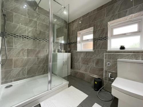 ein Bad mit einer Dusche, einem WC und einem Waschbecken in der Unterkunft Stylish 3 bedroom House In Grt Gregorie Basildon & Essex - Free Wifi, Parking, Dedicated Office & Private Garden in Basildon