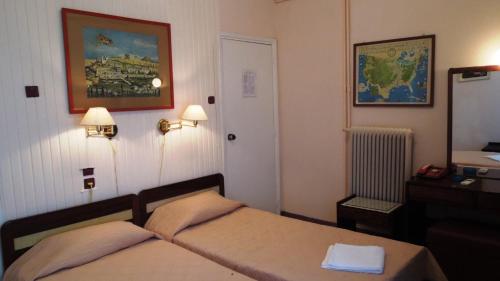 um quarto de hotel com uma cama e um espelho em Miramare Hotel em Atenas