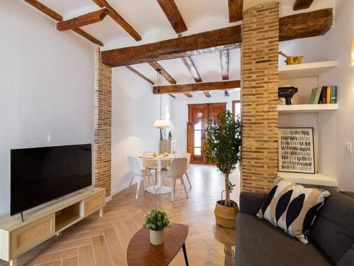 a living room with a couch and a tv and a table at Beautiful restored house with terrace in Valencia