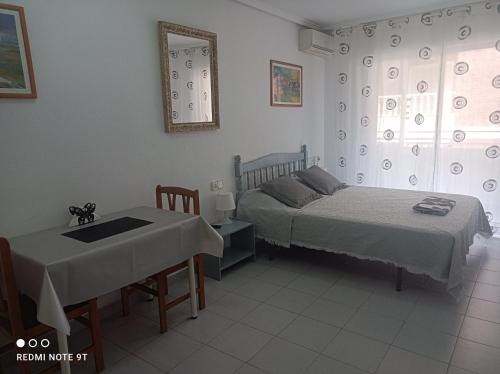 Habitación con 2 camas, mesa, mesa y cama en Studio Almudena, en Torrevieja