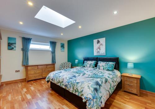 Great PlumsteadにあるOakdeneの青い壁のベッドルーム1室(ベッド1台付)