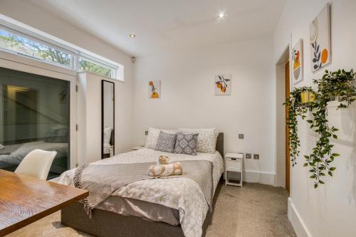 a bedroom with a bed with a teddy bear sitting on it at Stunning Award Winning Barn Conversion- 2 Bedroom in London