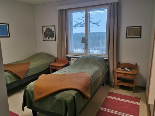 1 Schlafzimmer mit 2 Betten und einem großen Fenster in der Unterkunft Ulvovan Suden Majatalo 