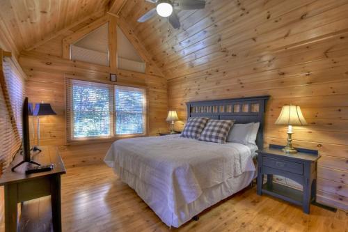 1 dormitorio con 1 cama en una cabaña de madera en Mountain Solace w Mtn Views Paved Roads Hot Tub, en Blue Ridge