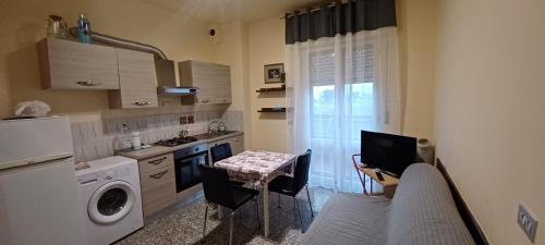 Luni的住宿－appartamento mare di Luni Mare，一间带桌子和冰箱的小厨房